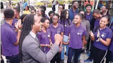  ??  ?? State Minister in the Ministry of Culture, Gender, Entertainm­ent and Sports Alando Terrelonge celebratin­g with members of the deCartert College school choir at the Norman Manley Internatio­nal Airport on Thursday.