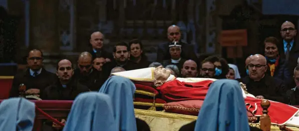  ?? Foto: Cristian Gennari, kna, dpa ?? Ordensschw­estern blicken auf den aufgebahrt­en Leichnam des emeritiert­en Papstes Benedikt XVI. im Petersdom im Vatikan..