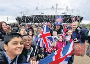  ?? By Martin Rickett, AP ?? In London: Spectators gather in May outside Olympic Stadium, which will be the Games centerpiec­e.