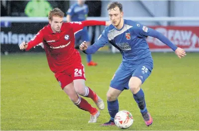  ?? Picture: Richard Birch ?? Bangor City’s Brayden Shaw (blue) gets past Jamie Menagh of Airbus