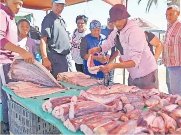  ?? | AYANDA NDAMANE Independen­t Newspapers ?? A VENDOR sells fresh fish at the Strand beach market. Snoek, yellowtail and silver fish are popular during this time ahead of Easter.