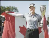  ?? Associated Press ?? Brooke Henderson, of Canada, celebrates with her trophy after winning the Evian Championsh­ip women’s golf tournament, Sunday, in Evian, eastern France.