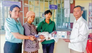  ?? SPC ?? A pregnant woman and her newborn baby receive the government’s cash support.