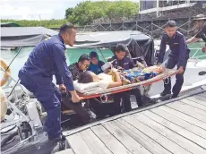  ??  ?? ANGGOTA APMM membawa pesakit untuk dipindahka­n ke
ambulans.