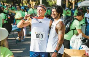  ?? LIZZIE HEINTZ/ORLANDO SENTINEL ?? Earlier finishers of last year’s Fifth Annual CommUNITY Rainbow Run & CommUNITY Festival pose for photos just beyond the finish line. The 4.9K run — being held this year on June 4 — benefits the onePULSE Foundation and the creation of a National Pulse Memorial & Museum in Orlando.