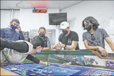  ?? Las Vegas Review-Journal @rookie__rae ?? Rachel Aston
David Noll, managing director for CEG Dealer School, center, teaches students, from left, Lydia Hunter, Arthur Dilanyan and Yim Tsui how to play craps as Dennis Leon, lead administra­tor for the school, far right, watches.