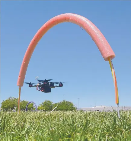  ?? GREG SORBER/JOURNAL ?? A quadcopter flies through a hoop in a practice race course set up at a park in Albuquerqu­e. The tiny drones are capable of flying up to 100 mph.