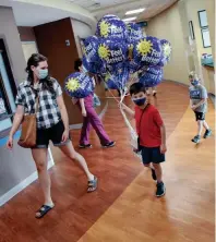  ?? PHOTOS BY ADAM CAIRNS/COLUMBUS DISPATCH ?? Seven-year-old George Raney always asks his father Aaron, a resident surgeon for Ohiohealth, about his day. So when George came up with the idea to hold a lemonade stand, it only made sense that he used the money he raised to buy balloons and cards for patients at his dad’s hospital.
TOP: George Raney, 7, brings a bunch of balloons to his dad, Aaron Raney, a resident surgeon at Ohiohealth Doctors Hospital, to hand out to his patients. George held a successful lemonade stand that raised more than $100 to pay for the balloons.