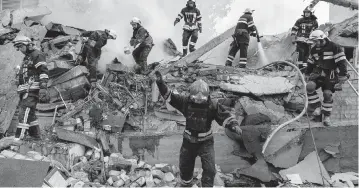  ?? EVGENIY MALOLETKA AP ?? Rescue workers clear the rubble of a school after an attack in Kharkiv, Ukraine, on Monday.