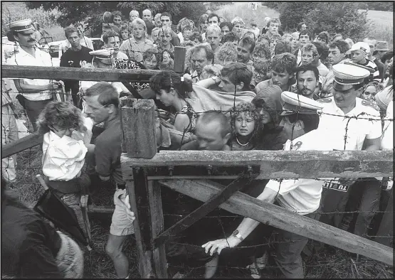  ?? [ Foto: Eisermann/Laif/Picturedes­k] ?? Ohne Waffengewa­lt: DDR-Bürger durchbrech­en den Grenzzaun nach Österreich bei Sopron, 19. August 1989.