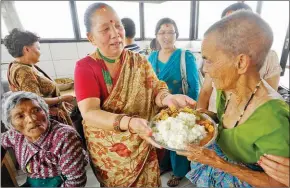  ?? PRAKASH MATHEMA/AFP ?? A Nepalese volunteer offers food to elderly residents of an on Mother’s Day in Kathmandu on May 9, 2013. (mother’s home),