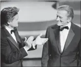  ?? AFP via Getty Images/tns ?? Michael Douglas (left) applauds his father Kirk Douglas (right) during the 57th Annual Academy Awards, on March 25, 1985, in Hollywood.