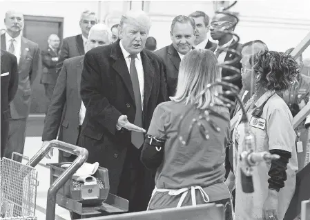  ?? EVAN VUCCI/ AP ?? President- elect Donald Trump greets workers during a visit to the Carrier Corp. factory in Indianapol­is on Dec. 1, 2016.