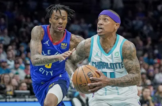  ?? Rusty Jones, The Associated Press ?? Charlotte Hornets guard Isaiah Thomas, right, dribbles past Denver Nuggets guard Bones Hyland during last Monday’s game in Charlotte, N. C. The veteran Thomas is mentoring the rookie Hyland.