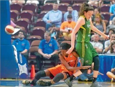  ?? TIM MARTIN/THE DAY ?? Jonquel Jones, left, of the Connecticu­t Sun falls into Seattle’s Breanna Stewart during the first half of a WNBA game earlier this week at Mohegan Sun Arena. The Sun host the Dallas Stars tonight.