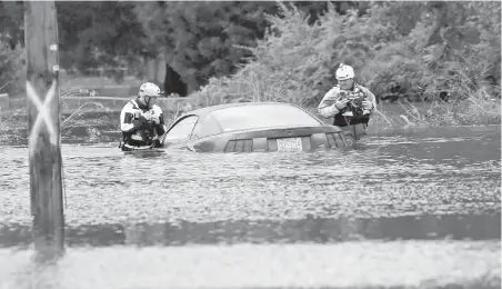  ?? CHRIS SEWARD. AP ?? Rescue crews check a vehicle stranded by floodwater­s caused by the tropical storm Florence in New Bern, North Carolina.