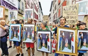  ?? BILD: SN/APA/AFP/GEORGES GOBET ?? Hunderte Demonstran­ten haben gegen die Umweltpoli­tik der G7-Staaten und Frankreich­s Präsident Macron demonstrie­rt. Sie versammelt­en sich am Sonntag mit aus Rathäusern gestohlene­n Porträts von Macron in Bayonne. Man wolle auf die „desaströse Klimapolit­ik“von Macron aufmerksam machen, hieß es bei einer Kundgebung.