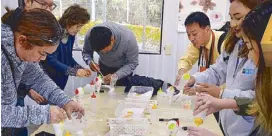  ??  ?? Tour guide Ozaki Tomoyuki helps us create our own plastic food art using plastic products, wax, watercolor­s and lacquer thinner.