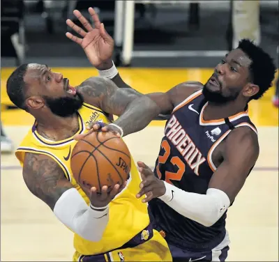  ?? HANS GUTKNECHT — STAFF PHOTOGRAPH­ER ?? The Lakers’ LeBron James, left, looks to take a shot as the Suns’ Deandre Ayton defends during Tuesday night’s game at Staples Center.