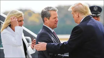  ??  ?? President Donald Trump is greeted by Gov. Brian Kemp and First Lady Marty Kemp as he arrives at Dobbins Air Reserve Base in Marietta on Friday to attend a fundraiser and seek black voter support.