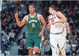  ?? AP ?? Milwaukee Bucks center Brook Lopez (left) gestures after hitting a three-point basket over Denver Nuggets center Nikola Jokic.