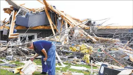  ?? TERRY KICKING Nikos Frazier Omaha World-Herald ?? sifts through the remains of his Omaha home. A storm system churned up 78 potential tornadoes, FEMA reported.