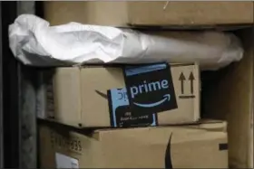  ?? MARK LENNIHAN — THE ASSOCIATED PRESS FILE ?? A package from Amazon Prime is loaded for delivery on a UPS truck, in New York. Shares of delivery companies FedEx and UPS are falling in Friday premarket trading following a report that powerhouse Amazon is readying its own delivery service for...