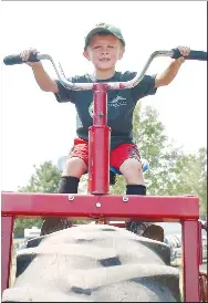  ?? Westside Eagle Observer/RANDY MOLL ?? Paxton Smith sits atop a tractor-sized tricycle at the Tired Iron of the Ozarks fall show in Gentry on Saturday, Sept. 11, 2021.