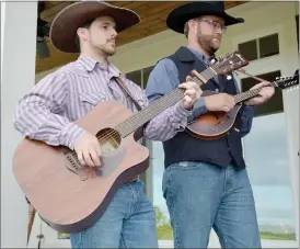  ??  ?? Andrews (left) plays the guitar and sings lead vocals while Braschler strums the mandolin and sings tenor.