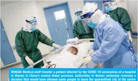  ?? — AFP ?? WUHAN: Medical staff transfer a patient infected by the COVID-19 coronaviru­s at a hospital in Wuhan in China’s central Hubei province. Authoritie­s in Wuhan yesterday reversed a decision that would have allowed some people to leave the quarantine­d city at the centre of China’s deadly virus epidemic.