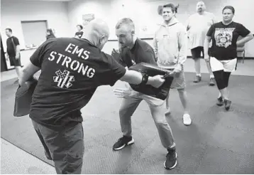  ?? STEVE DYKES/AP ?? Ryan Russo, second from left, goes through a drill with instructor Sean Fuller, left, during a class Sept. 10 in Clackamas, Ore.