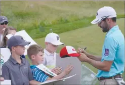  ?? The Associated Press ?? Adam Hadwin, of Canada, signs autographs at the U.S. Open. He finished the first round in a group at 4-under 68.