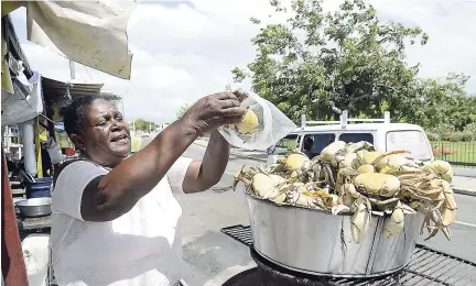  ?? IAN ALLEN PHOTOS ?? Normadelle Raymond puts the cooked crab in a plastic bag.