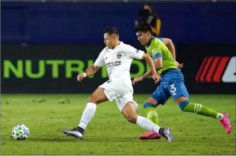  ?? AP PHOTO/ASHLEY LANDIS ?? LA Galaxy forward Javier Hernandez, left, takes a shot for a goal ahead of Seattle Sounders defender Xavier Arreaga during the second half of an MLS soccer match Wednesday in Carson, Calif.