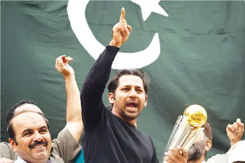  ?? — AFP photo ?? Pakistani cricket captain Sarfaraz Ahmed acknowledg­es fans as he holds the Champions Trophy following his arrival from London in Karachi on June 20, 2017, after Pakistan’s win in the Internatio­nal Cricket Championsh­ip (ICC) Champions Trophy final...