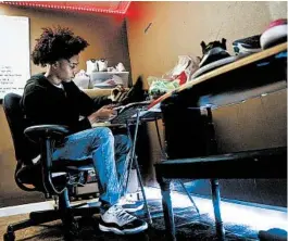  ?? ERIC ALBRECHT/COLUMBUS DISPATCH ?? Antonio Davis reconditio­ns a pair of sneakers at his home. The sneaker side business gives him something more to do and earn some extra money during the pandemic.