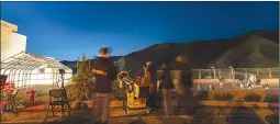  ?? Chris Torres/The Signal ?? Event attendees look through telescopes under the night sky at COC.