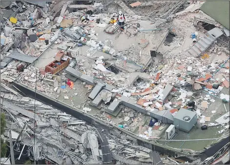  ?? (AP) ?? A Red Cross worker stands (top center), on a collapsed building where rescuers continue searching for people trapped inside, in the Roma Note neighborho­od of Mexico on Sept 20.