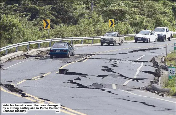  ?? EPA ?? Vehicles transit a road that was damaged by a strong earthquake in Punto Palmar, Ecuador Tuesday.