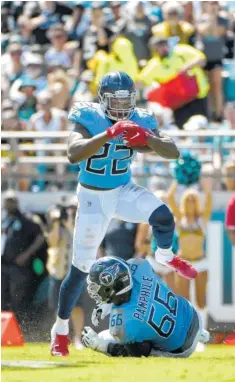  ?? AP FILE PHOTO/PHELAN M. EBENHACK ?? Tennessee Titans running back Derrick Henry leaps over lineman Kevin Pamphile while rushing for yardage against Jacksonvil­le on Sept. 23. Henry looks to contribute more to the run game as the Titans play at Buffalo today.