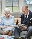  ?? C. Jackson/Buckingham Palace/PA Media, dpa ?? Das Kleid der Queen war mit 10 000 Perlen bestickt. Glückwunsc­hkarten erinnerten das Paar an diesen Tag im Jahr 1947.Fotos:
