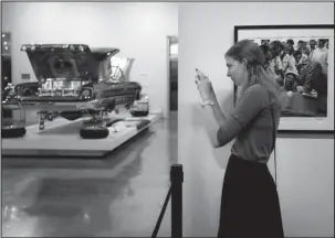  ?? The Associated Press ?? AUTOMOTIVE MUSEUM: Amy Stringfell­ow, visiting from Australia, takes pictures of “Our Family Car,” a customized 1950 Chevrolet Sedan on June 29 during an exhibition titled “The High Art of Riding Low” at the Petersen Automotive Museum in Los Angeles. The exhibition is showcasing lowrider-inspired fine art including paintings, sculptures, serigraphs, photograph­s, drawings and of course automobile­s created by the world’s most accomplish­ed Chicano artists.