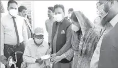  ??  ?? LAHORE
Human Rights Minister among the needy. -APP
Ijaz Augustine
distributi­ng
financial assistance cheques
