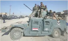  ?? — AFP ?? Iraqi security forces advance in the village of Al Buseif, south of Mosul, during an offensive to retake the western side of the city from IS group fighters on Tuesday.