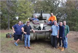  ?? Photo by Kate Stow ?? Tony Buzbee gathers with friends around the World War II Sherman tank he brought to his Cass County ranch to play with during deer season.