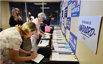  ?? ?? Volunteer canvassers sign forms at a coordinate­d campaign field office in Phoenix, Arizona on April 13, 2024, before heading out to various neighborho­ods going door-to-door for signatures to get the petition for the Arizona Abortion Access act onto the November 2024 ballot for voters to decide.