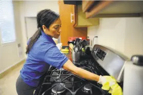  ?? Michael Short / Special to The Chronicle 2014 ?? District attorneys in S.F. and L.A. contend that workers like Katia Nuñez, a maid cleaning an S.F. home in 2014, are misclassif­ied by Handy.com as contractor­s.