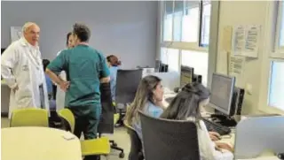  ??  ?? Sala de trabajo de médicos. Cada año llegan de fuera de Sevilla más de 35 para aprender nuevas técnicas. Con ellos, con la bata blanca, Francisco Murillo, director de la unidad de gestión de Cuidados Intensivos