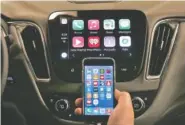  ?? PHOTO BY PAUL SANCYA ?? An iPhone is connected to a 2016 Chevrolet Malibu equipped with Apple CarPlay apps, displayed on the car’s MyLink screen, top, during a demonstrat­ion in Detroit.