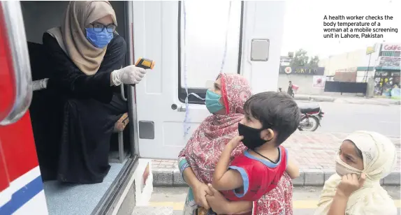  ??  ?? A health worker checks the body temperatur­e of a woman at a mobile screening unit in Lahore, Pakistan